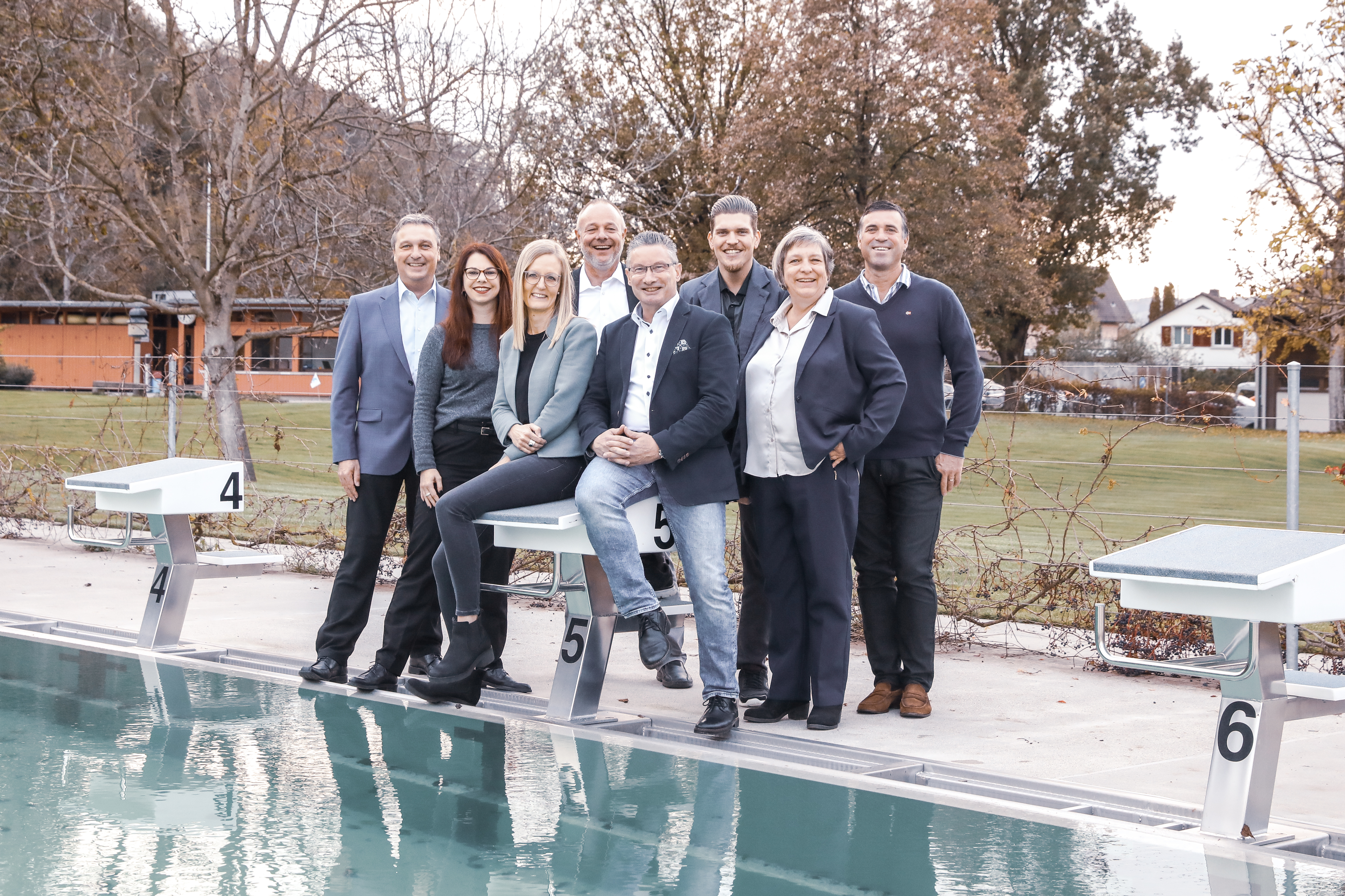 Gruppenfoto Gemeinderatsmitglieder und Gemeindeschreiber aufgenommen am Beckenrand im Freibad Wisengrund