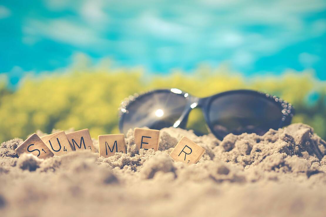 Sand mit Buchstaben SUMMER und Sonnenbrille